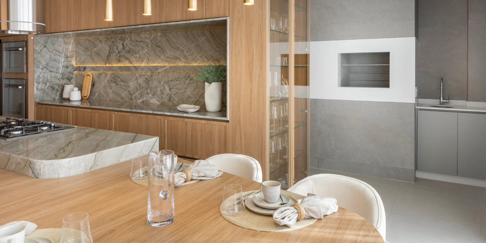 Cozinha do apartamento do Tremezzo com bancada de mármore e cooktop
